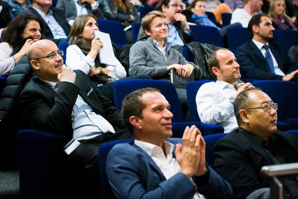 The audience reacts and applauds in an auditorium.