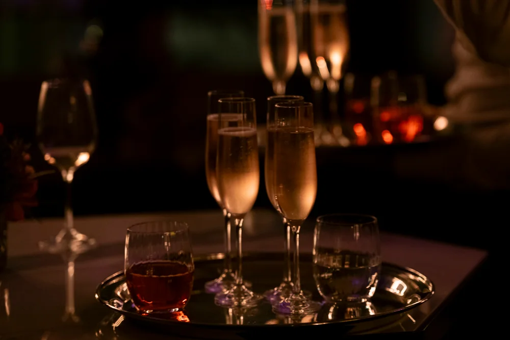 Flutes on a tray in candlelight.