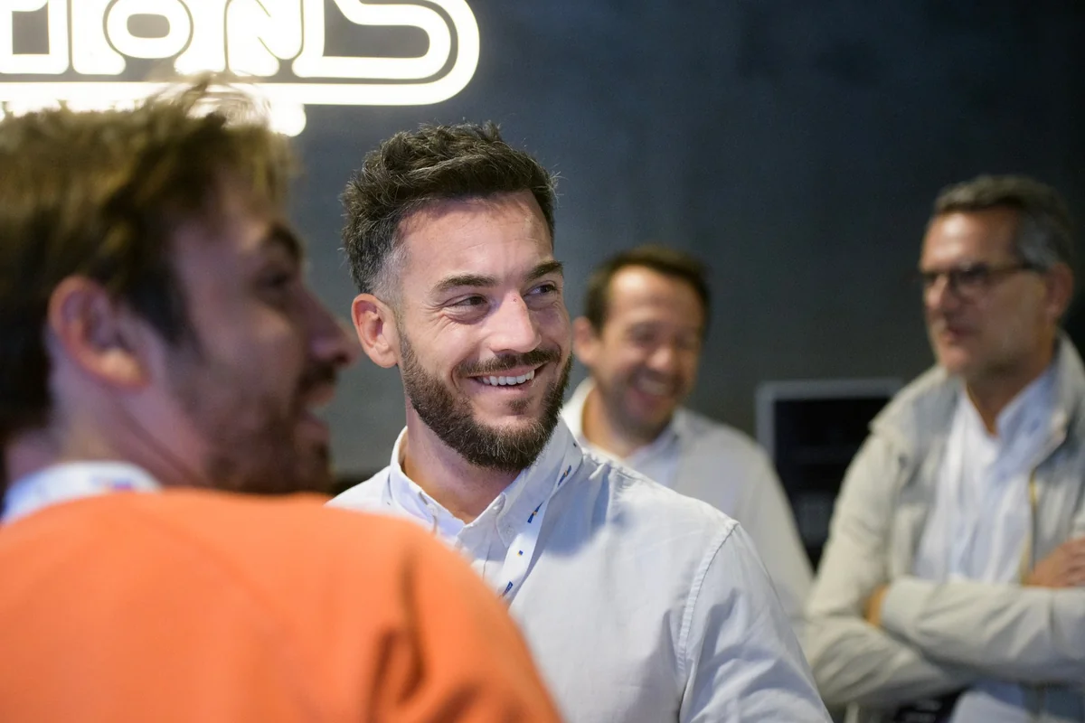 A smiling attendee talks with a small group.