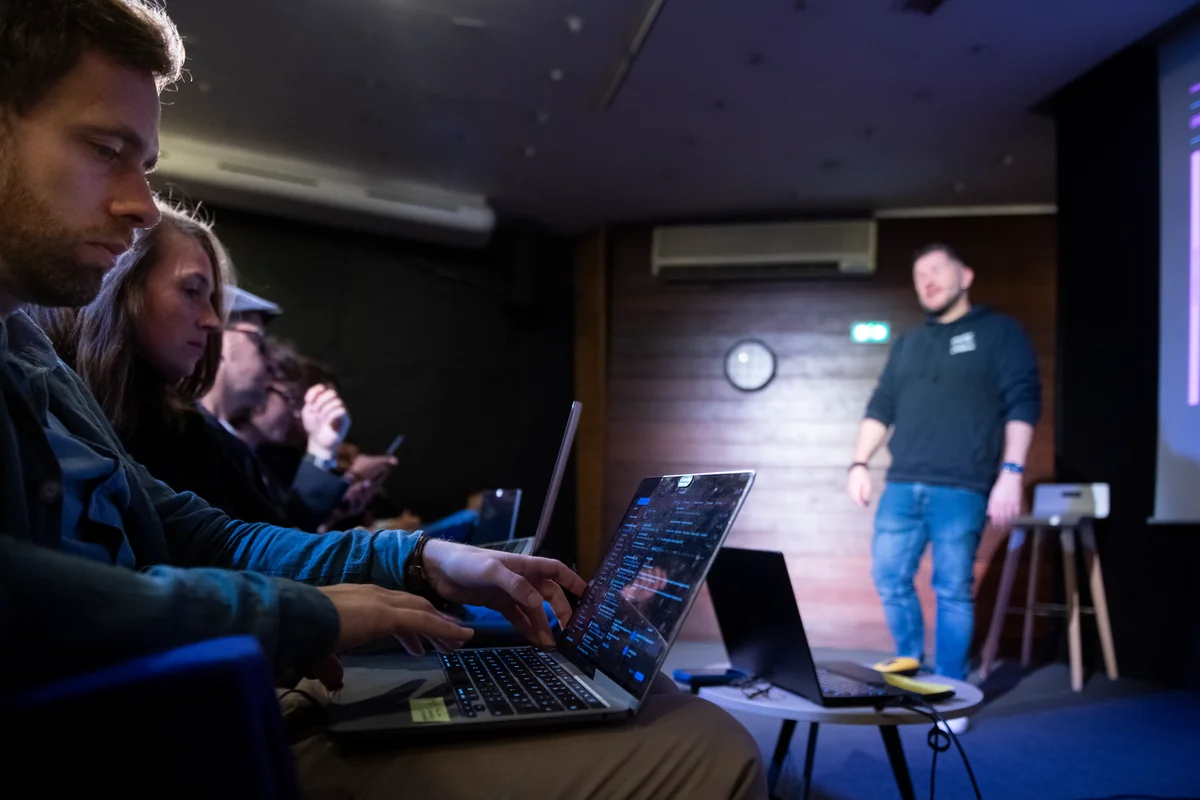 Attendees taking notes on their laptops during a conference