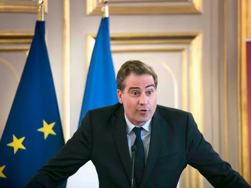 Speaker at a lectern in front of the French and European flags.