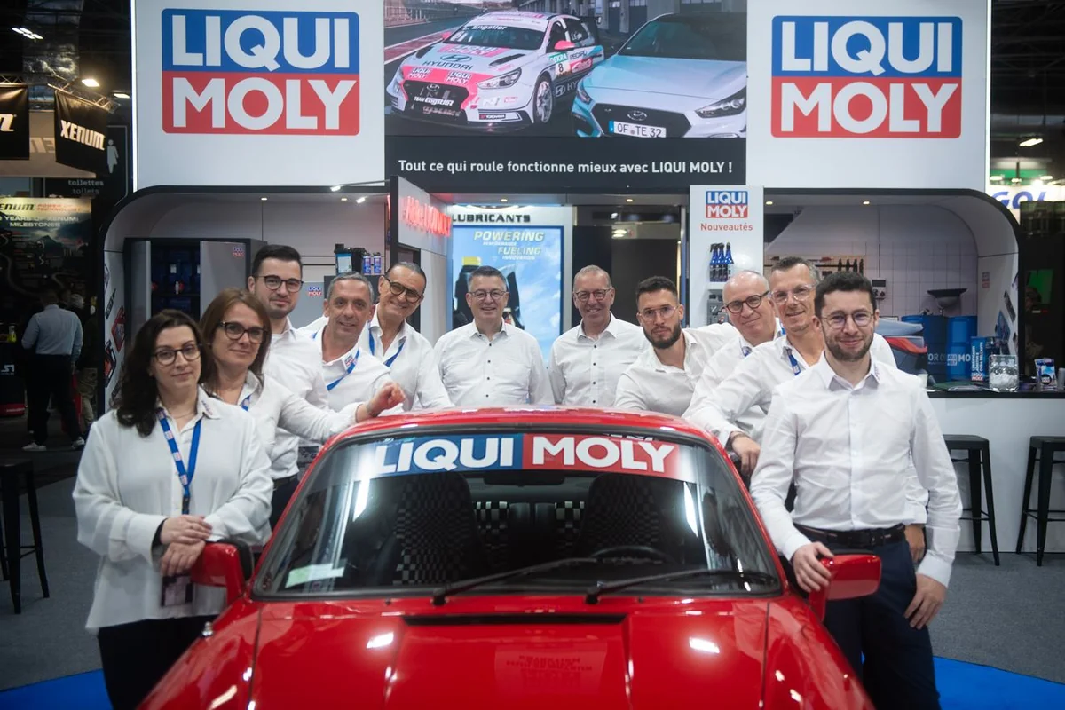 L’équipe LIQUI MOLY réunie autour d’une voiture rouge sur son stand.