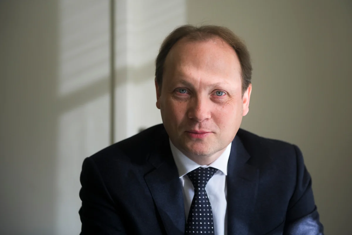 Portrait of a man in a suit and tie in a bright interior.