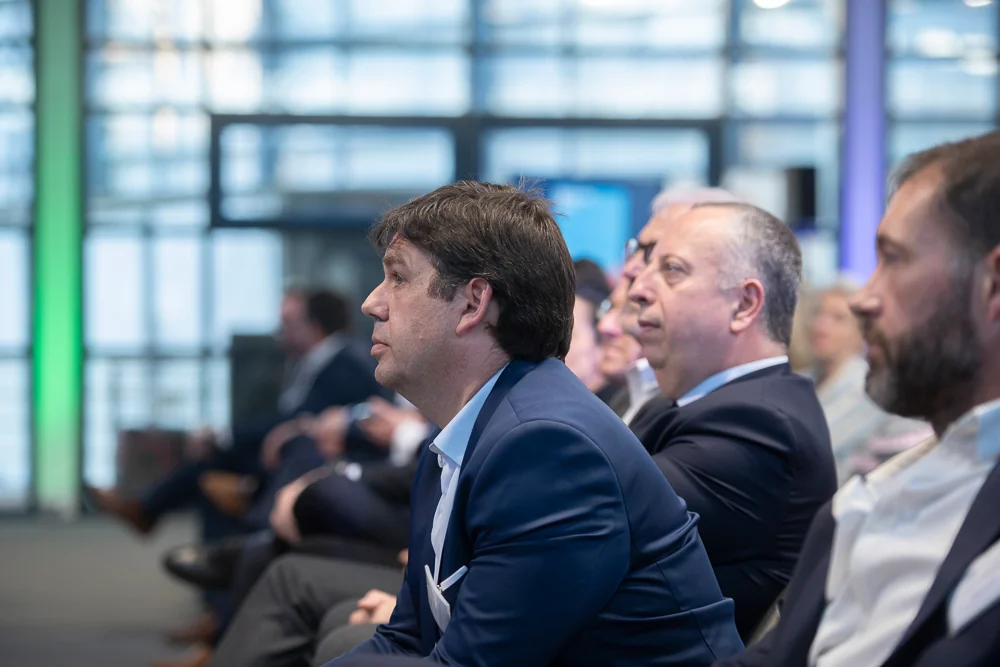 Attendees follow a talk from the front row.