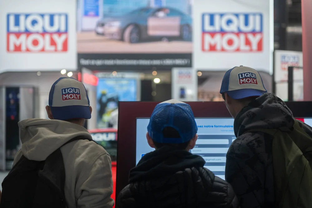 Visitors in front of the LIQUI MOLY stand signage.