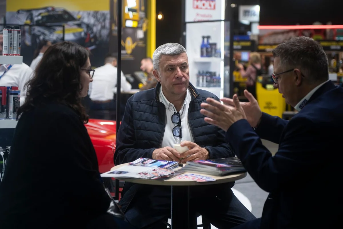 Trois personnes échangent autour d’une table sur le stand LIQUI MOLY.