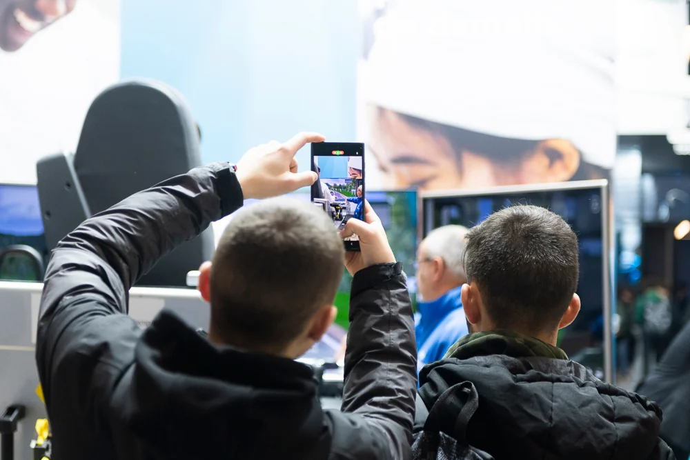 A visitor photographs a presentation with a phone.